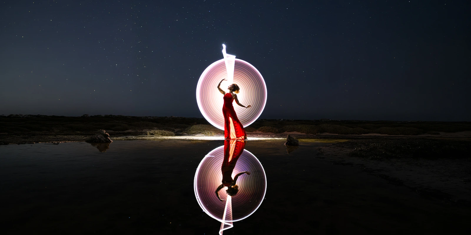 Students practicing long-exposure photography during a light-painting workshop at night